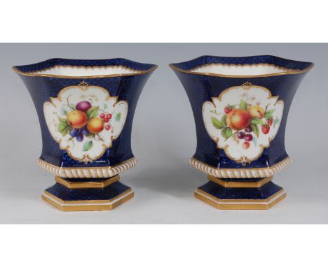 *A pair of Royal Worcester porcelain vases, each of waisted hexagonal form, the central reserve hand-painted with fruit on a 