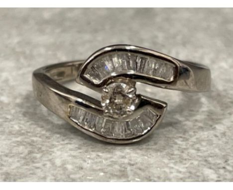 14ct white gold Diamond ring. Set with Baguette and central Brilliant cut Diamond. Size N 2.8g