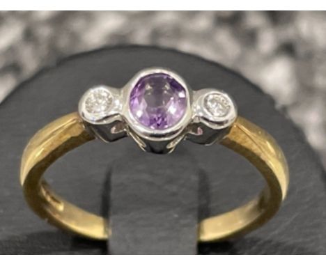 Ladies 9ct gold 3 stone ring. Comprising of oval purple stone and Round brilliant cut diamond. 2.3G size O