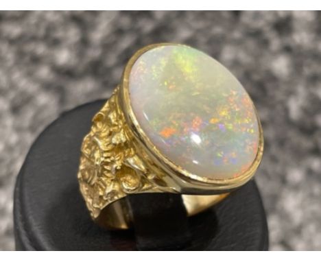 Oval 9ct gold ring set with large oval Opal (20mm x 15mm) with patterned shoulders. 7.7g size O