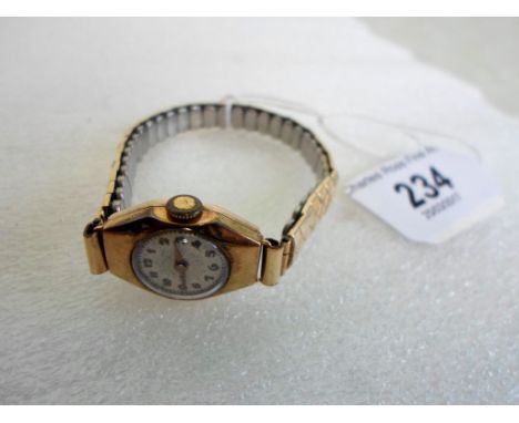 A lady's 9ct gold cased wristwatch, the circular enamel dial bearing Arabic numerals, to a yellow and white metal elasticated