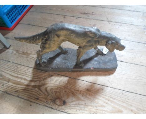 An early 20th century painted terracotta model of a dog, after E. Rouff, bearing a plaque titled 'Chien Épagneul', 21cm x 36c