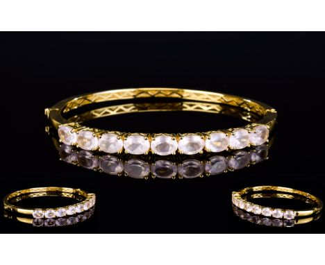Rose Quartz Hinged Bangle, 12cts of oval cut, faceted rose quartz, set in a row to the front of the gold plated, hinged bangl