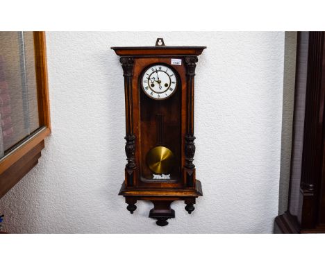 Vienna Wall Clock of typical form, white enamel dial, Roman Numerals, spring driven movement with pendulum. 