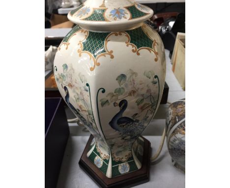 AN ORIENTAL STYLE TABLE LAMP BASE 30CM HIGH AND A LIDDED JAR DECORATED WITH PEACOCKS 