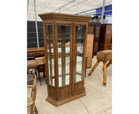 A MODERN OAK TWO DOOR DISPLAY CABINET WITH MIRRORED INTERNAL BACK AND BOTTOM SHELF, WITH FOUR CLEAR GLASS SHELVES, THE DOORS 