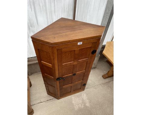 A MID 20TH CENTURY ROBERT 'MOUSEMAN' THOMPSON OAK CORNER CUPBOARD WITH PANELLED DOOR, HAVING CAST IRON LATCH AND HINGES, 27" 