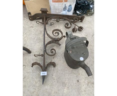 A VINTAGE WROUGHT IRON HANGING BASKET BRACKET AND A BRASS KETTLE 