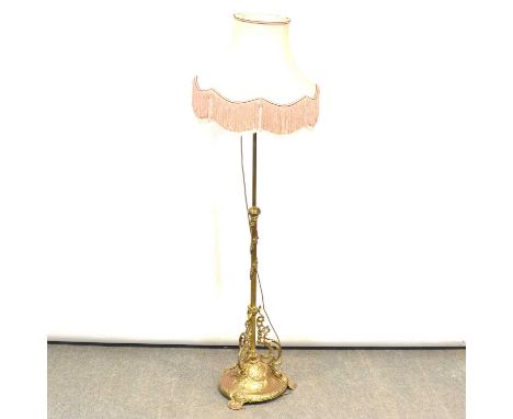 Edwardian brass standard lamp, basket top, fluted and floral column above scrolled brackets, domed base on rococo feet, with 