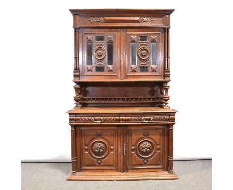 A 19th century French oak dresser, profusely carved, the upper section with two glaze doors enclosing two shelves, over an op