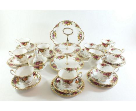 A Royal County Roses tea service comprising: nine cups and saucers, cake plate, eight tea plates, cake stand, milk, sugar and