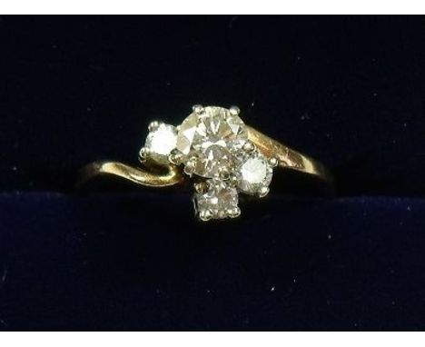 A 14 carat gold four stone crossover ring set one large and three smaller diamonds - size K 1/2 - 1.9g