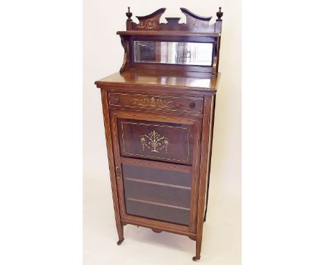 An Edwardian rosewood cabinet with mirror back shelf over frieze drawer and part glazed door enclosing shelves, the whole wit