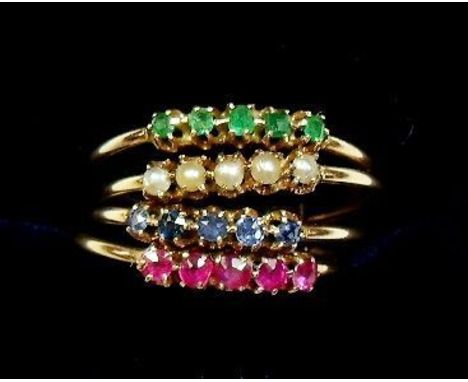 A 15 carat gold four band ring set emeralds, pearls, sapphires and rubies, size K