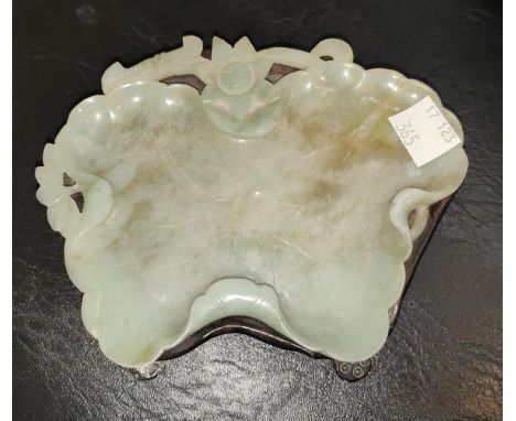 A Chinese jade elephant on hardwood stand, length 10cm; a jade leaf shaped bowl on hardwood stand, length 13cm 
