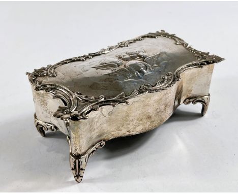 A hallmarked silver shaped rectangular jewellery box, the hinged lid with cherub head relief decoration and acanthus border, 