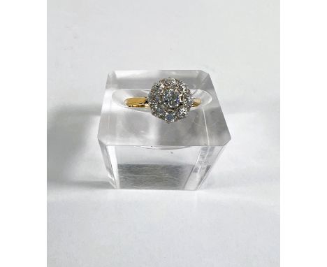 A lady's yellow metal dress ring with diamonds in flowerhead setting, central stone approx. 4mm diameter, stamped 18ct, gross