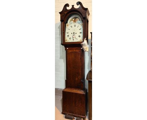 An early 19th century oak longcase clock with swan neck pediment and reeded side columns to the hood, full length door, arche