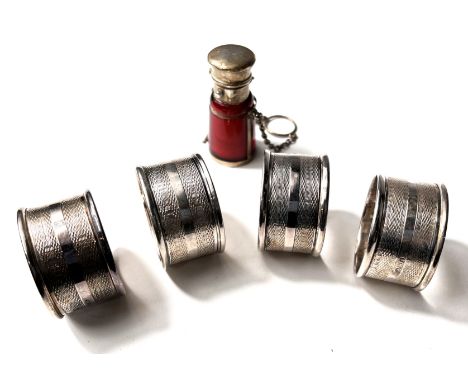 A hallmarked silver set of engine turned napkin rings, Birmingham 1945, 2oz; a silver mounted whisky &amp; water jug with lab