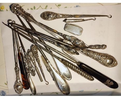 A collection of silver and other handled button hooks 