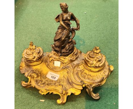 A 19th century French brass and bronze inkstand in the rococo manner with semi clad female figure, 2 covered inkwells, height