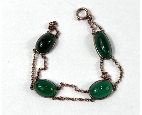 A yellow metal bracelet set with 4 oval jade stones (tests at 9ct) 10.2gm gross 