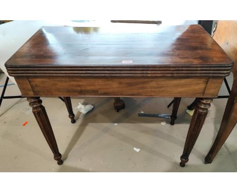 A 19th century mahogany Gillows style fold over tilt top card table with ribbed rounded edges, reeded tapering legs, green ba