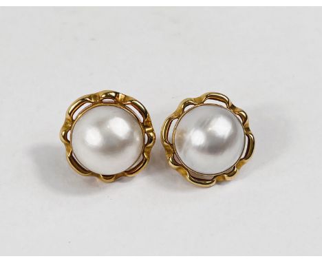 A yellow metal pair of pierced earrings set with large mabe pearls in pierced surround with solid back, stamped '18ct', maker