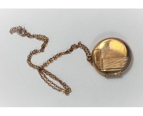 An engine turned circular locket stamped '9ct', on fine chain, 5.7gm 