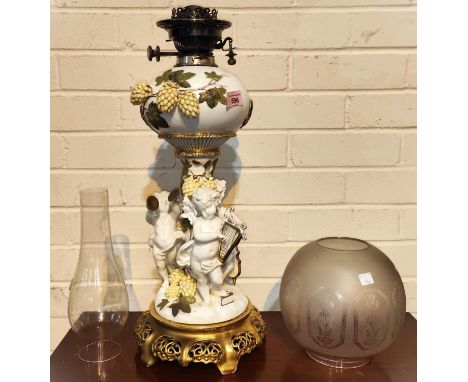 A 19th century ornate table lamp by Moore's, encrusted with flowers and leaves, the column supported by 3 cherubs playing ins