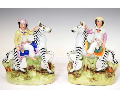 Pair of Staffordshire figures of zebras with riders, 18cm high