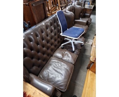A Queen Anne style brown leather Chesterfield three seater sofa and two matching wingback armchairs. 
