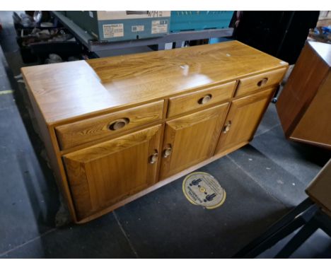 An Ercol light elm sideboard. Condition- generally good, left two doors possibly slightly swollen and can only be opened/clos