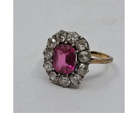 A precious yellow metal, diamond and ruby cluster ring, set oval mixed cut ruby to centre (ERW 1.5 carats), bordered by eleve