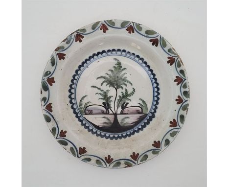 An early 18th century Lambeth Delftware plate, painted in colours, N.C.S. Exhibition Leeds 1974 label verso, diameter 23.8cm.