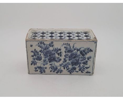 A mid 18th Lambeth Delftware flower brick, painted in blue, length 15.4cm.Condition note: loss of glaze to edges, chip to bas
