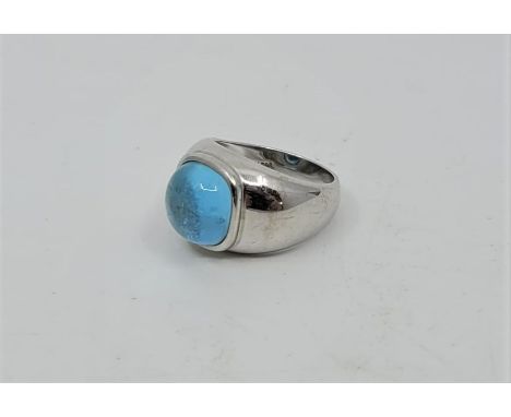 A 14ct. white gold and blue topaz ring, bezel set light blue topaz cabochon. (9.6g). Size approx. UK N 1/2, with certificate 