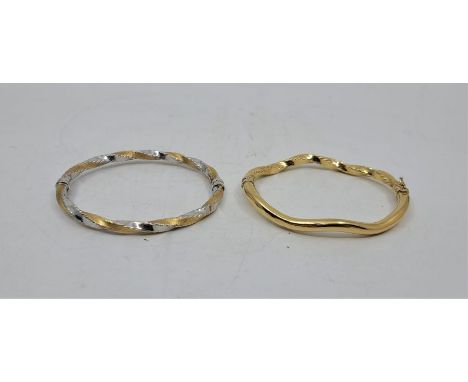 An 18ct. gold bi-colour eliptical hinged bangle, the yellow gold with brushed finish, the white gold with polished finish, to
