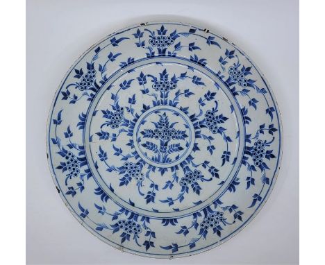 An 18th century English Delftware charger, painted in blue, diameter 33.9cm, height 4cm.Condition note: restored, loss of gla