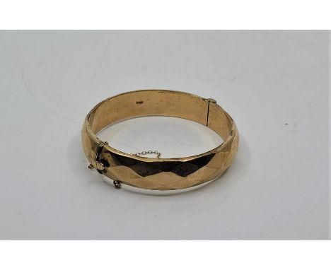 A 9ct. gold hinged circular hinged bangle, faceted to exterior. (18.1g)&nbsp;