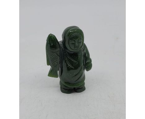 A carved dark green jade figure of an Inuit fisherman holding salmon, height 7.5cm.Further images added. 