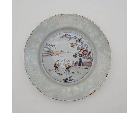 A mid 18th century English Delftware plate, painted bianco-sopra-bianco to rim and in colours to reserve, diameter 22.5cm.Con