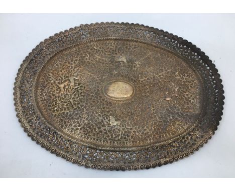 An early 20th century Indian white metal presentation oval plate, repousse scrolling foliage and forest animals, with pierced