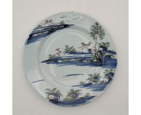 An 18th century English Delftware plate, painted in colours, diamrter 22.5cm.Condition note: a small loss of glaze to rim, ot