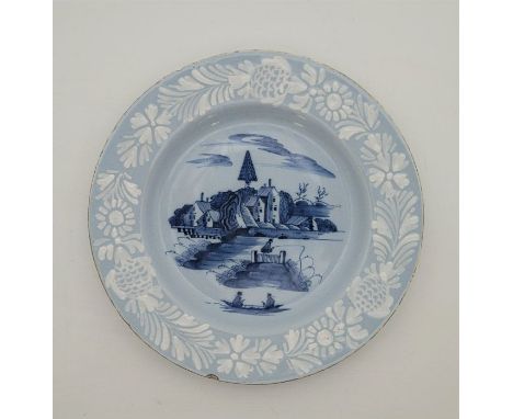A mid 18th century English Delftware plate, the rim decorated bianco-sopra-bianco, to pale blue glaze, reserve painted in blu