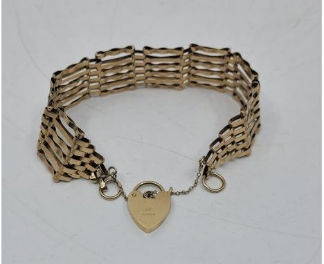 A 9ct. gold gate bracelet with heart padlock clasp, width 20mm x length 18cm. (12.2g)