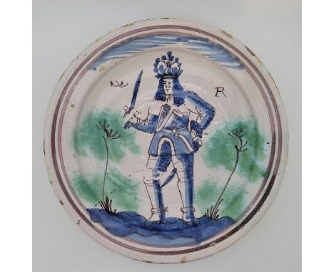 A late 17th century William III (1650-1702) English Delftware charger, painted in blue and green, diameter 35.0cm, height 5.8