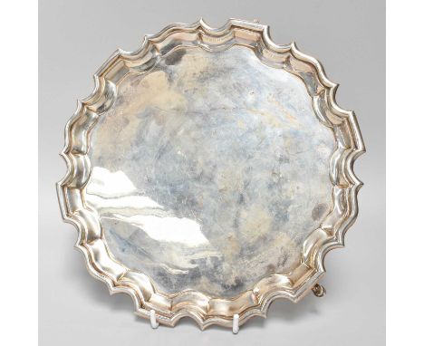 A George V Silver Salver, by Carrington and Co., London, 1936, in the George III style, shaped circular and on three panel fe