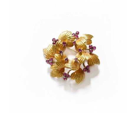 A Ruby Brooch, the circular frame composed of yellow textured leaves spaced by single round cut rubies, to a border similarly