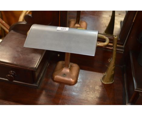 A copper and brass desk lamp and a small brass horn